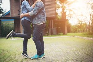 Hipster couple in love kissing in summer sun light. Love kiss standing. photo