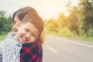 Little cute asian boy hug with her mom and smiling to camera happy time. photo