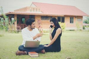 Young education couple was reading in the outdoors and good weather. And they're happy, Lifestyle concept. photo