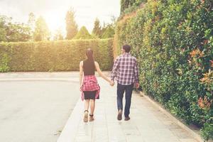 Young hipster couple holding hands walking in urban. photo