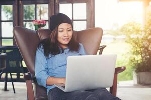 hermosa joven hipster sentada con su laptop y café por la mañana, disfruta y diviértete. foto