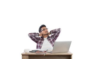 Young businessman relaxing at workplace thoughtful with work isolated on white background. photo