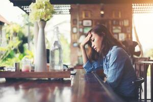 mujer joven sentada en un café con su computadora portátil, estresante para el trabajo. foto