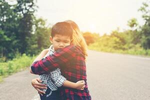 Little cute asian boy hug with her mom and smiling to camera happy time. photo