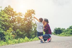 Mom and son pointing something in the park. photo