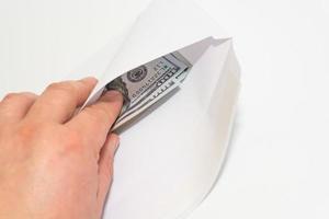 A man takes out money dollars from a white envelope photo