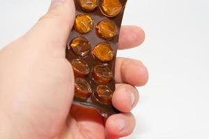 A man holds a used blank blister from under pills in his hand. photo