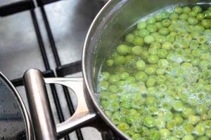 Cooking green peas in a saucepan photo