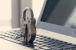 concepto de seguridad en Internet: candado antiguo y llave en el teclado de la computadora portátil foto