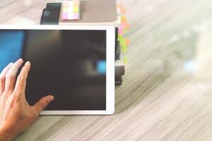 Website designer working blank screen digital tablet and books with smart phone on wooden desk as concept photo