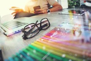 eye glass on wooden desk with Website designer working digital tablet and computer laptop with smart phone and digital design diagram as concept photo