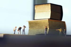Creative idea concept - miniature photographer with vintage golden book on open paper notebook photo