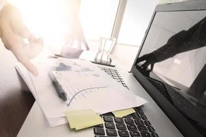 Close up of business man hand working on laptop computer with social media diagram and chart graph on wooden desk as concept photo