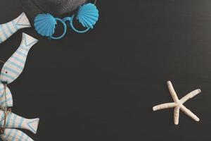 Summer and Holiday concept.beach accessories on dark wooden board photo