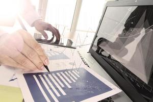 Close up of business man hand working on laptop computer with social media diagram and chart graph on wooden desk as concept photo