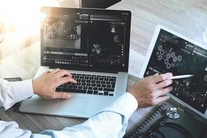 médico que trabaja con tableta digital y computadora portátil con teléfono inteligente en la oficina del espacio de trabajo médico y videoconferencia como concepto foto