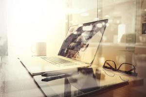 Office workplace with laptop and smart phone on wood table and london city blurred background photo