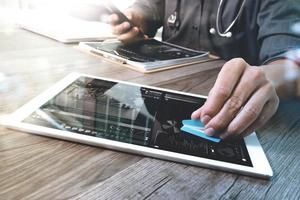 Medical technology concept. Doctor hand working with modern digital tablet and laptop computer with medical chart interface, Sun flare effect photo