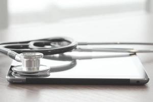 studio macro of a stethoscope and digital tablet on wood table background copy space photo