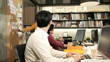 Casual female staff worker use the bicycle to go home after work finished, greeting together and saying goodbye to young Asian male colleagues and coworkers in a multiracial corporate business office. video