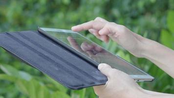 smartphone e giardino. utilizzando smartphone tablet nel cortile. video