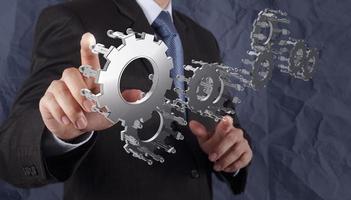 businessman hand shows gear to success concept photo