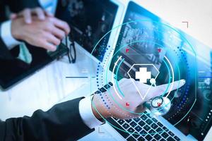 Medical technology network team meeting concept. Doctor hand working smart phone modern digital tablet laptop computer graphics chart interface, sun flare effect photo