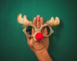 vasos de navidad que decoran con renos de navidad y bola roja a mano sobre fondo verde foto