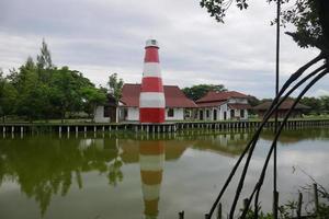 red and white lighthouse on the edge of the swamp photo