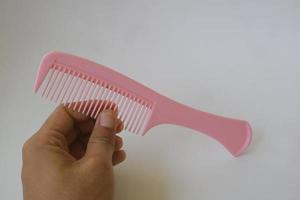 hands holding pink hair comb photo
