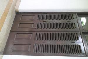 wide wooden door with ventilation holes photo