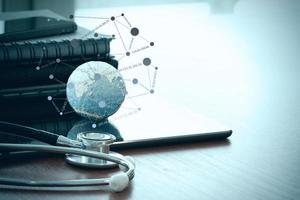 stethoscope and texture globe with digital tablet as medical network concept photo