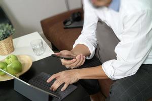 hipster hand using digital tablet docking keyboard and mobile payments online business,omni channel,sitting on sofa in living room,green apples in wooden tray photo