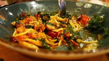 espaguete com frutos do mar picantes em um prato com um garfo. frutos do mar com espaguete e especiarias. video