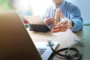 Handshake helping for business Medical technology concept. Doctor hand working with modern digital tablet dock screen computer with medical chart interface, Sun flare effect photo