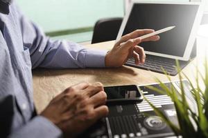 Businessman hand working concept. Documents finance graphic chart. Digital tablet keyboard dock screen computer design smart phone using. Eyeglass on marble desk. Sun flare effect photo