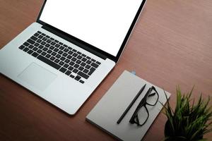 Office workplace with laptop and smart phone on wood table photo