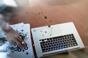 vista superior de la mano del médico que trabaja con una computadora moderna y un teléfono inteligente en un escritorio de madera como concepto médico foto