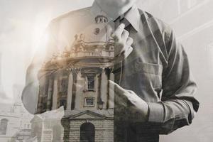 Double exposure of success businessman holding neck tie with London building,front view,filter effect photo