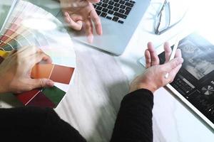 two colleague web designer discussing data and digital tablet and computer laptop with smart phone and design diagram on marble desk as concept photo