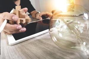 creative hand showing wood puzzle and light bulb with laptop computer and tablet computer as design concept photo