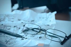 composing music concept with shallow DOF evenly matched jack of headphone and crumpled musical notes paper photo