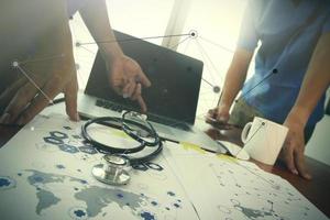 médico del equipo que trabaja con una computadora portátil en la oficina del espacio de trabajo médico y el diagrama de medios de la red médica como concepto foto