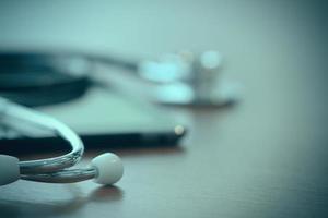 Studio macro of a stethoscope and digital tablet with shallow DOF evenly matched abstract on wood table background copy space photo