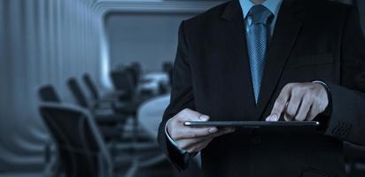 Businessman hand working with a digital tablet on meeting room photo