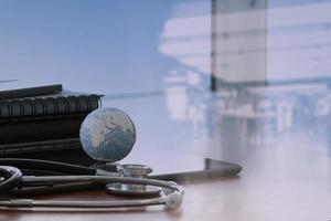 stethoscope and texture globe with digital tablet as medical network concept photo