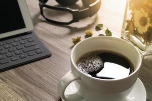 taza de café y base de mesa digital teclado inteligente, florero de hierbas, auriculares de música, anteojos en mesa de madera, efecto de filtro foto