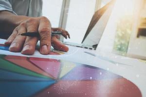 documentos de negocios en la mesa de oficina con teléfono inteligente y tableta digital y diagrama de negocios gráfico y hombre trabajando en segundo plano foto