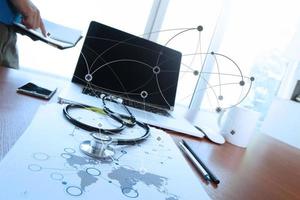 Doctor working with laptop computer in medical workspace office and medical network media diagram as concept photo