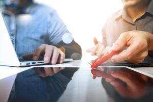 Team work concept,businessman hand attending video conference in modern office.Digital tablet laptop computer design smart phone using. Sun effects, Blurred background photo